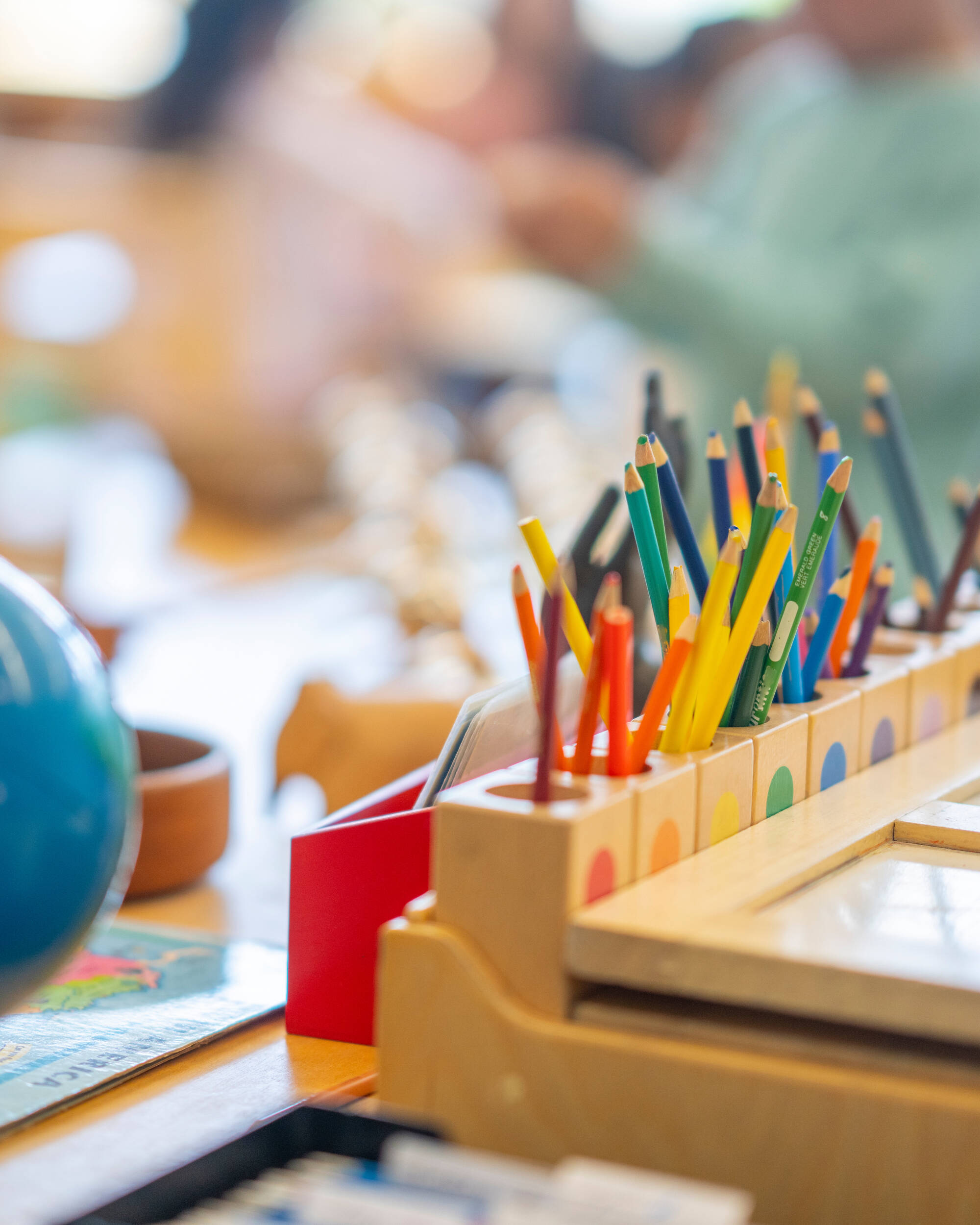 Colored pencils and globe on desk